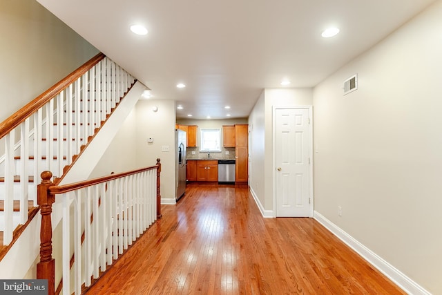 interior space featuring light wood-style floors, baseboards, visible vents, and recessed lighting