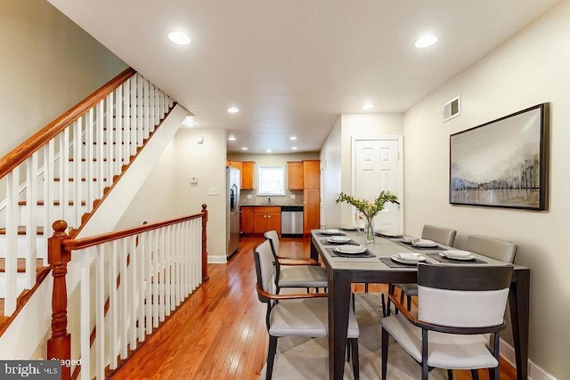 dining space featuring visible vents, baseboards, light wood-type flooring, and recessed lighting