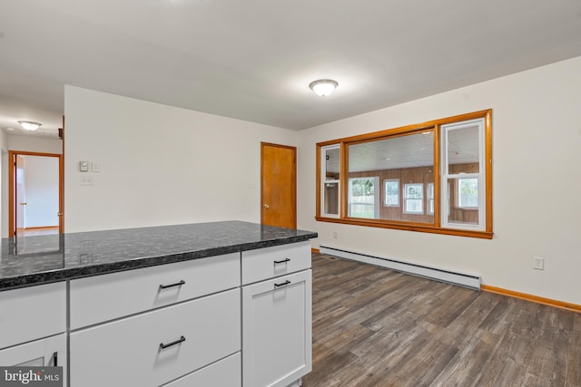 kitchen with baseboards, dark wood-style floors, white cabinets, dark stone counters, and a baseboard radiator
