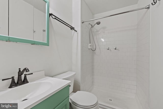 full bath featuring toilet, tiled shower, and vanity