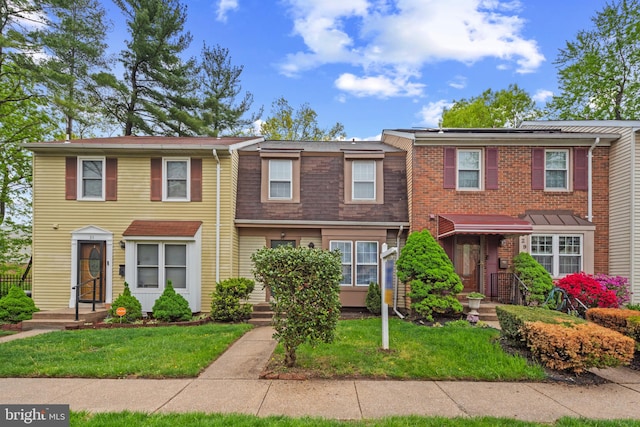 townhome / multi-family property with a front yard