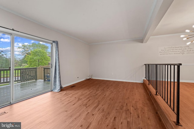 unfurnished room with crown molding, wood finished floors, and baseboards