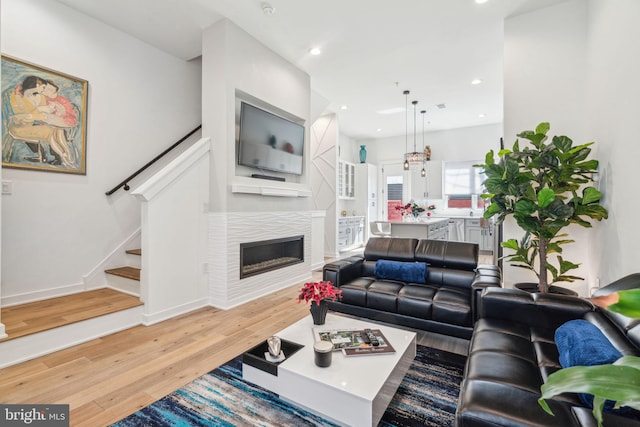 2237 N Hope St, Philadelphia, PA 19133 - living room featuring recessed lighting, light wood-style floors, a glass covered fireplace, and stairs