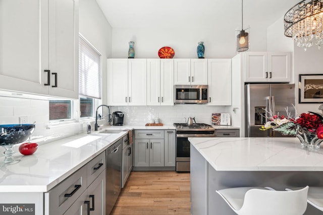 2237 N Hope St, Philadelphia, PA 19133 - kitchen featuring backsplash, appliances with stainless steel finishes, light stone countertops, and a sink