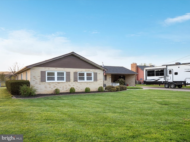 ranch-style home featuring brick siding and a front yard