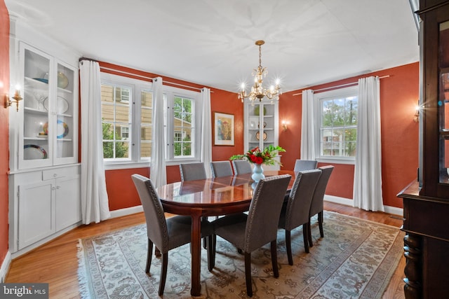 dining area featuring a chandelier, plenty of natural light, and light wood finished floors