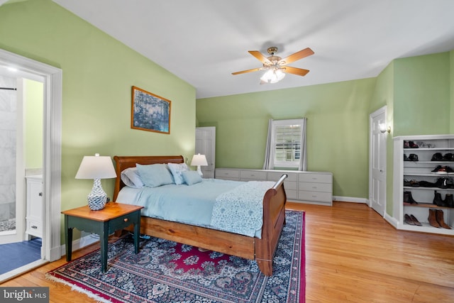 bedroom with wood finished floors, ceiling fan, ensuite bathroom, and baseboards