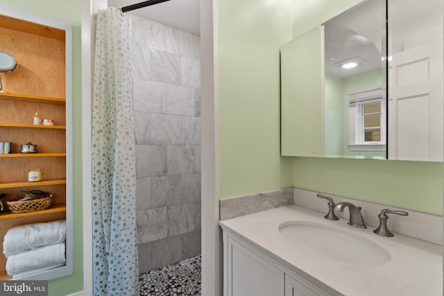 full bathroom with tiled shower and vanity