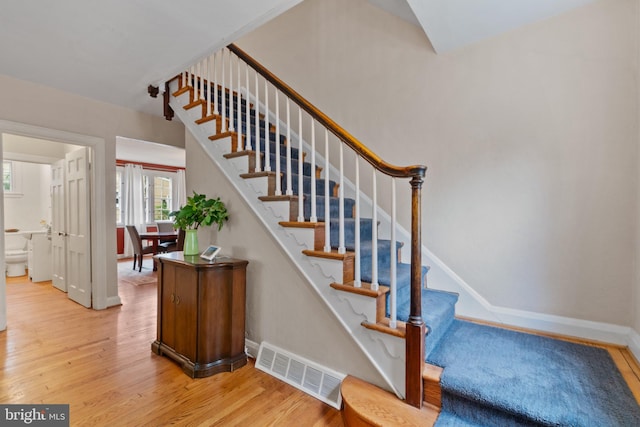 stairs with wood finished floors and baseboards