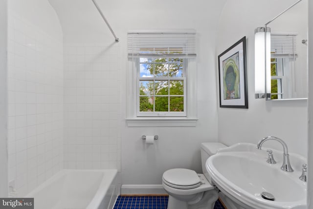 bathroom featuring a sink, toilet, bathing tub / shower combination, baseboards, and tile patterned floors