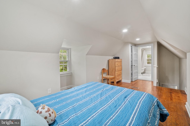 bedroom with wood finished floors, lofted ceiling, connected bathroom, baseboards, and recessed lighting