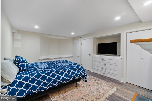 bedroom featuring wood finished floors and recessed lighting
