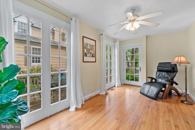 sitting room featuring wood finished floors, baseboards, and ceiling fan