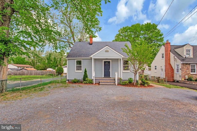 bungalow-style home featuring roof with shingles, fence, a chimney, and driveway