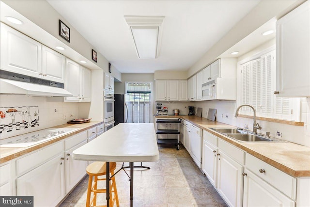 615 Brandon Rd, Norristown, PA 19403 - kitchen featuring white appliances, under cabinet range hood, a sink, white cabinetry, and recessed lighting