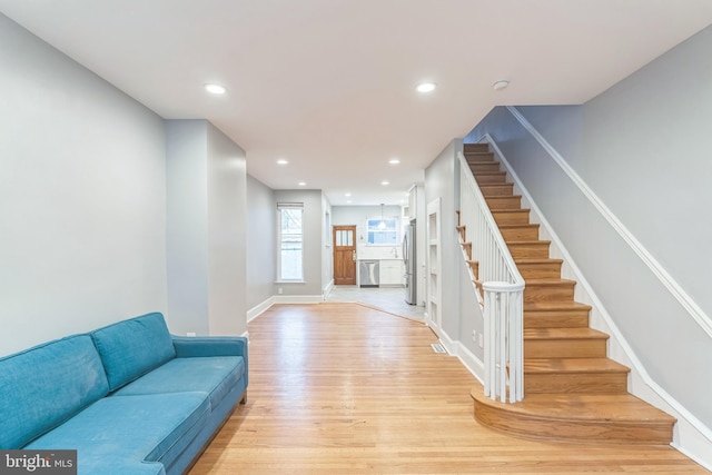 interior space featuring recessed lighting, light wood finished floors, visible vents, baseboards, and stairs