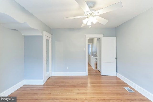 spare room with a ceiling fan, baseboards, and light wood-style floors