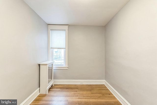 spare room with baseboards and light wood-style flooring