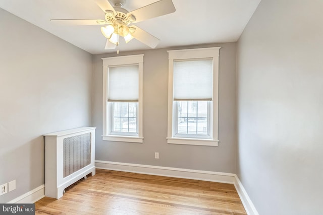 spare room featuring light wood-style flooring, baseboards, and ceiling fan