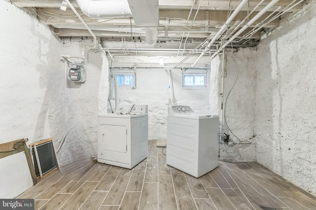 clothes washing area with wood finished floors, washer and clothes dryer, and laundry area