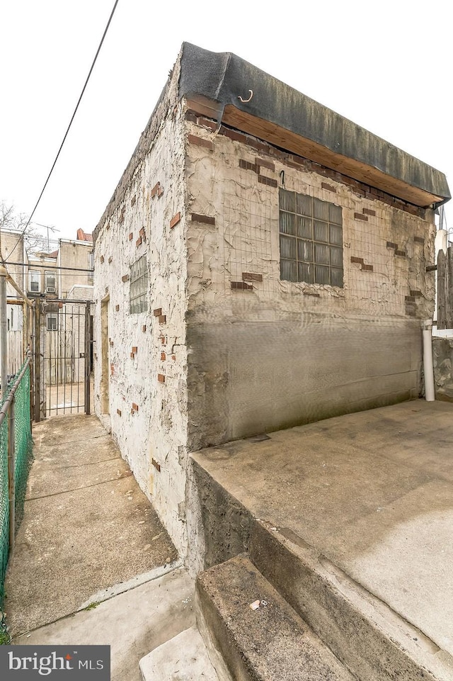 view of side of property featuring a gate and fence