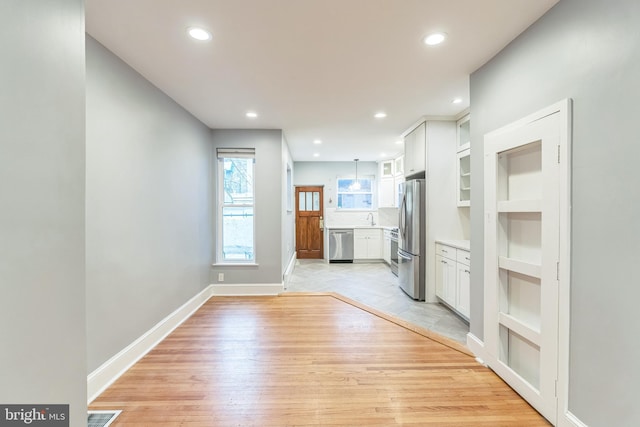 interior space featuring light wood-style floors, built in shelves, baseboards, visible vents, and recessed lighting