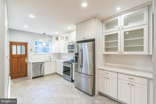 kitchen with recessed lighting, white cabinets, a sink, tasteful backsplash, and appliances with stainless steel finishes