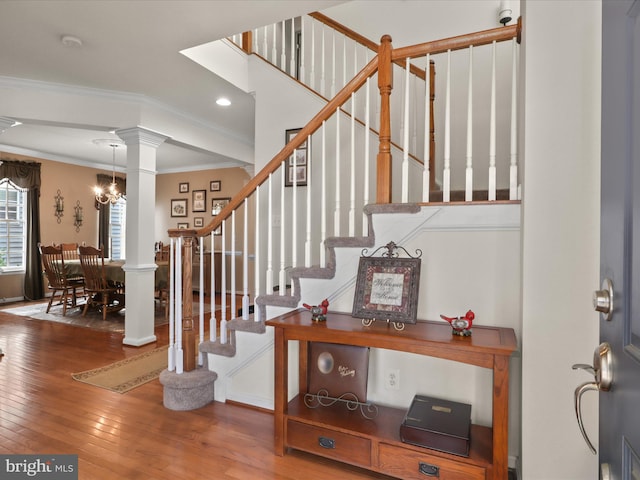 stairway featuring ornate columns, crown molding, recessed lighting, and wood-type flooring
