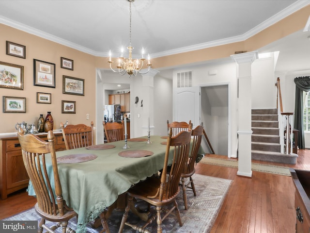 dining space featuring stairs, an inviting chandelier, crown molding, and wood-type flooring