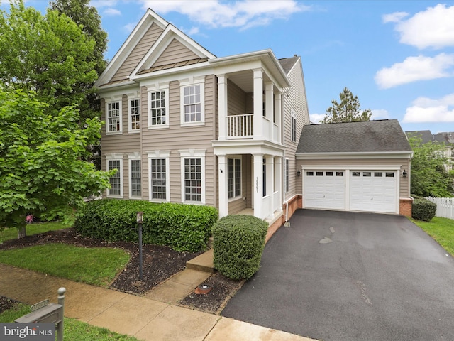 view of front of house with a balcony, driveway, and an attached garage