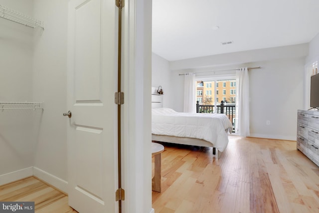 bedroom featuring light wood-style floors, baseboards, access to outside, and visible vents