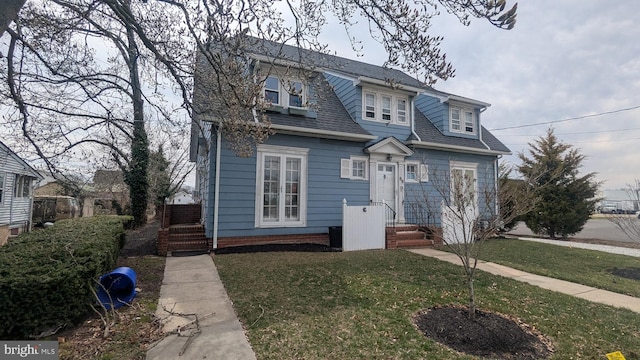 view of front of house featuring a front yard and roof with shingles
