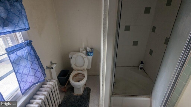 full bathroom with toilet, an enclosed shower, and radiator heating unit