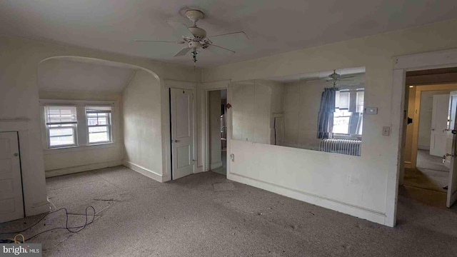 unfurnished living room featuring baseboards, a ceiling fan, and carpet floors