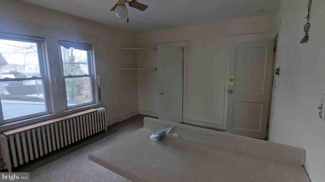 interior space with a closet, radiator heating unit, and ceiling fan