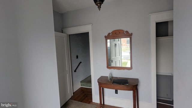 corridor with baseboards and wood finished floors