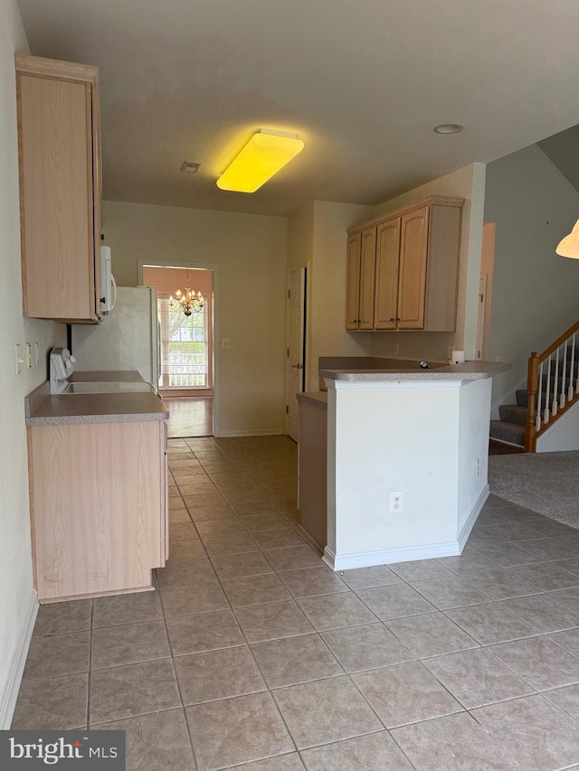 kitchen with an inviting chandelier, light brown cabinetry, and light tile patterned floors