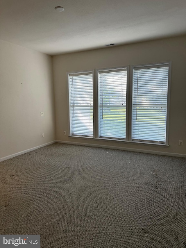 carpeted empty room with baseboards and visible vents