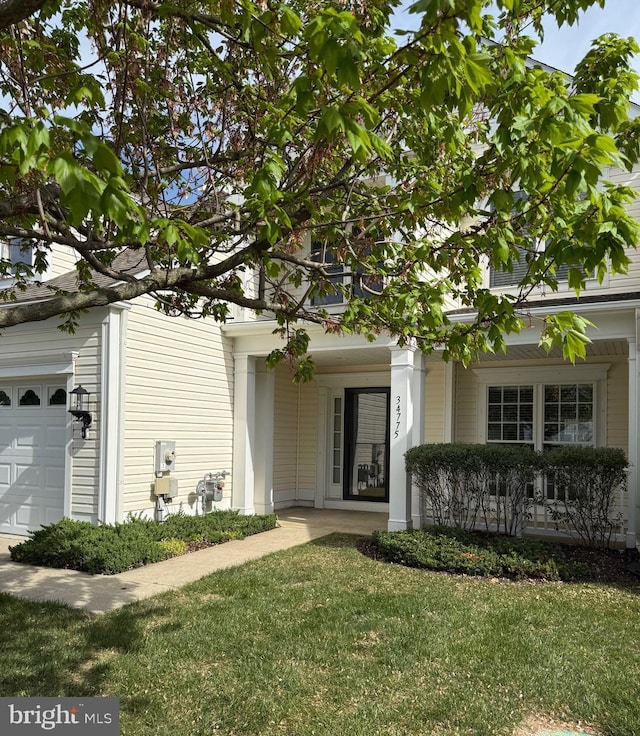 exterior space featuring a lawn, an attached garage, and a porch