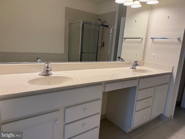 bathroom featuring tile patterned floors, a shower stall, and a sink