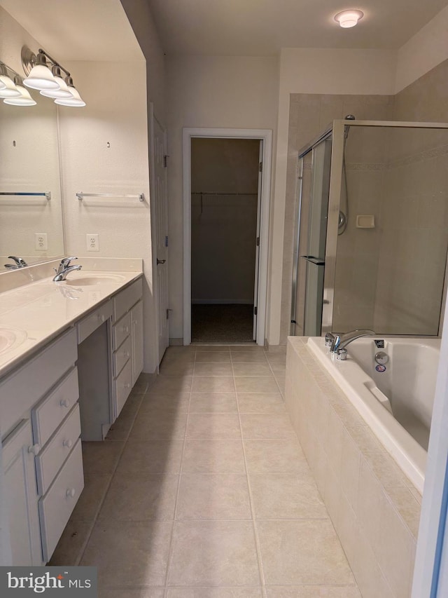 full bathroom featuring double vanity, tile patterned flooring, a stall shower, a sink, and tiled bath
