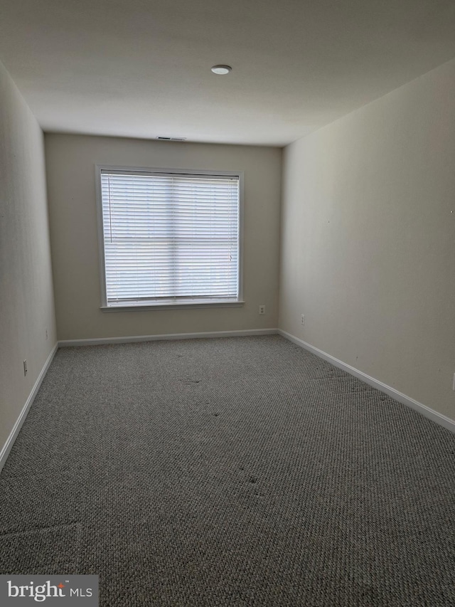 carpeted empty room with baseboards