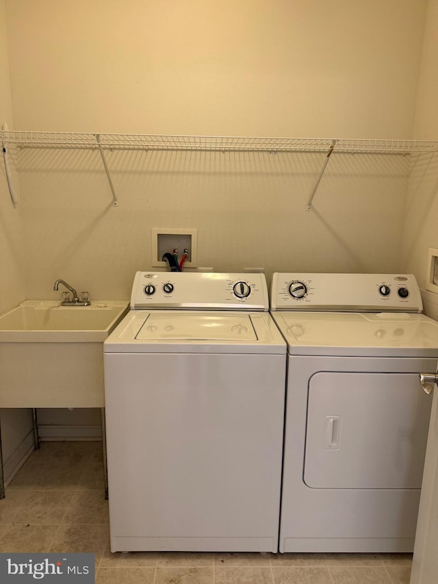 washroom with a sink, separate washer and dryer, and laundry area