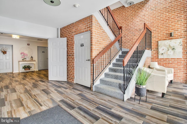 12105 Tullamore Ct Unit 101, Lutherville Timonium, MD 21093 - staircase featuring brick wall and wood finished floors