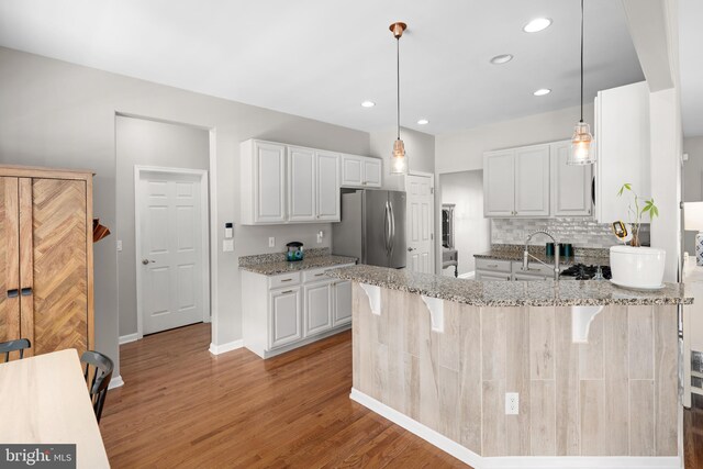 16260 Edgewater Dr, Milton, DE 19968 - kitchen with freestanding refrigerator, light stone counters, light wood-style flooring, a sink, and recessed lighting