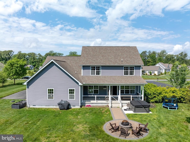 16260 Edgewater Dr, Milton, DE 19968 - back of property with a fire pit, a trampoline, a yard, and roof with shingles