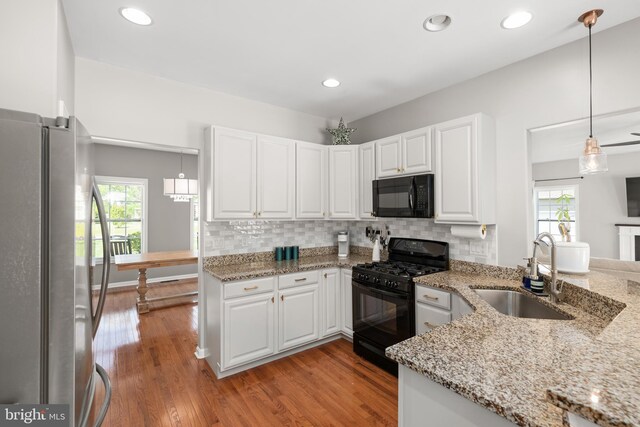 16260 Edgewater Dr, Milton, DE 19968 - kitchen featuring black appliances, a sink, light wood finished floors, white cabinetry, and recessed lighting