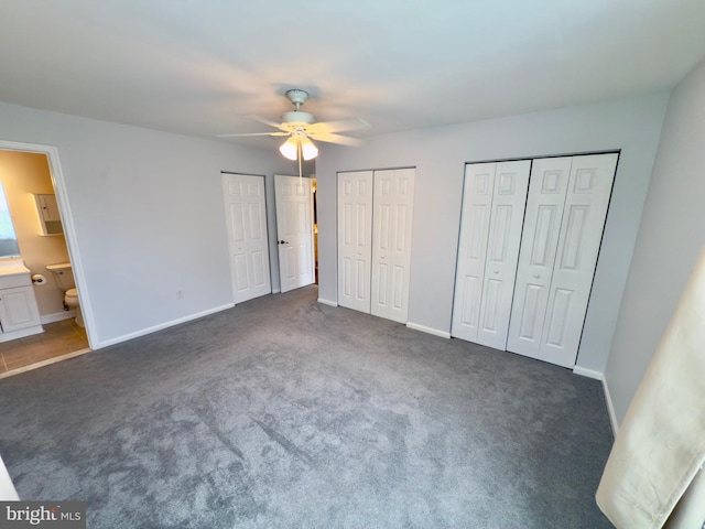 unfurnished bedroom with multiple closets, baseboards, and carpet floors