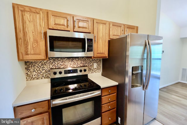 kitchen with light countertops, tasteful backsplash, and appliances with stainless steel finishes