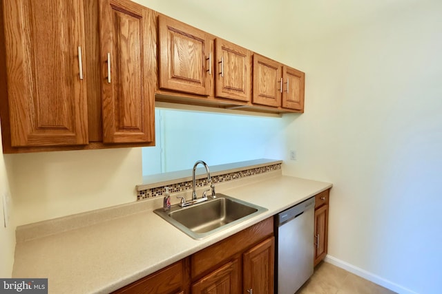 kitchen featuring dishwasher, brown cabinets, a sink, and light countertops